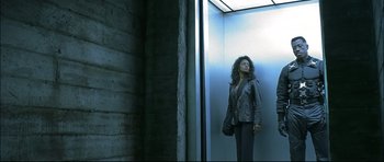 Movie still from “Blade” (1998), directed by Stephen Norrington – A woman standing in an elevator with her hand in her purse; Medium shot, Low angle