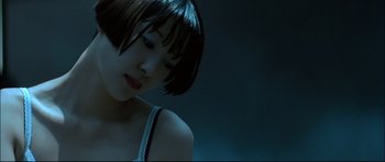 Movie still from “Blade” (1998), directed by Stephen Norrington – A woman with short black hair is looking down at her face; Close Up shot, Low angle