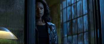 Movie still from “Blade” (1998), directed by Stephen Norrington – A woman in a black jacket standing in front of a window; Close Up shot, Over the shoulder angle