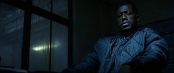 Movie still from “Blade” (1998), directed by Stephen Norrington – A man sitting in front of a window in a dark room; Close Up shot, Low angle