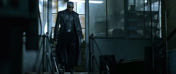 Movie still from “Blade” (1998), directed by Stephen Norrington – A man in a black outfit walking down a set of stairs; Medium shot, Low angle