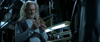Movie still from “Blade” (1998), directed by Stephen Norrington – A man holding a piece of food in his hands; Medium shot, Over the shoulder angle
