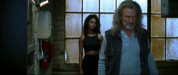 Movie still from “Blade” (1998), directed by Stephen Norrington – A man and a woman standing next to each other in front of a brick wall; Medium shot, Low angle
