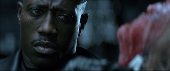 Movie still from “Blade” (1998), directed by Stephen Norrington – A man's face in the dark; Close Up shot, Over the shoulder angle