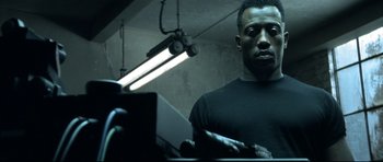 Movie still from “Blade” (1998), directed by Stephen Norrington – A man standing in front of a mirror in a dark room; Close Up shot, Low angle