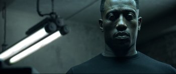 Movie still from “Blade” (1998), directed by Stephen Norrington – A person wearing a black t - shirt; Close Up shot, Low angle