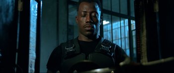 Movie still from “Blade” (1998), directed by Stephen Norrington – A man in a black shirt and a black jacket; Close Up shot, Low angle