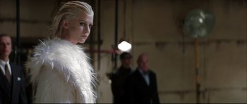 Movie still from “Blade” (1998), directed by Stephen Norrington – A woman in a white fur coat standing in front of two men; Close Up shot, Low angle