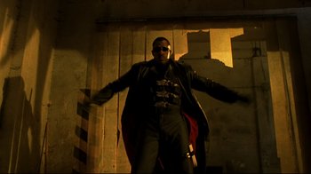 Movie still from “Blade II” (2002), directed by Guillermo del Toro – A man in a black leather jacket and a red cape; Medium shot, Low angle