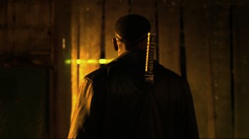 Movie still from “Blade II” (2002), directed by Guillermo del Toro – A man in a leather jacket with a microphone on his head; Close Up shot, Over the shoulder angle