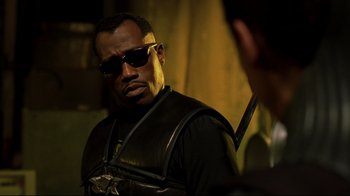 Movie still from “Blade II” (2002), directed by Guillermo del Toro – A man wearing sunglasses and holding a sword; Close Up shot, Low angle
