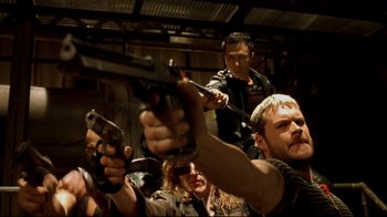 Movie still from “Blade II” (2002), directed by Guillermo del Toro – A group of people holding guns in a room; Medium shot, High angle