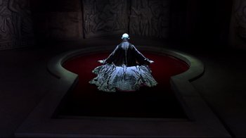 Movie still from “Blade II” (2002), directed by Guillermo del Toro – A woman in a black dress sitting on a red carpet; Wide shot, High angle