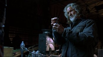 Movie still from “Blade II” (2002), directed by Guillermo del Toro – An older man holding a camera in a workshop; Medium shot, Low angle