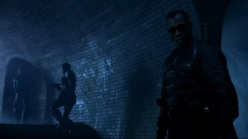 Movie still from “Blade II” (2002), directed by Guillermo del Toro – A man standing next to another man in a dark tunnel; Wide shot, Low angle