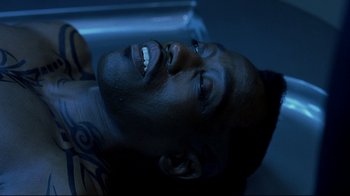 Movie still from “Blade II” (2002), directed by Guillermo del Toro – A man laying on the ground in a dark room; Close Up shot, Overhead angle