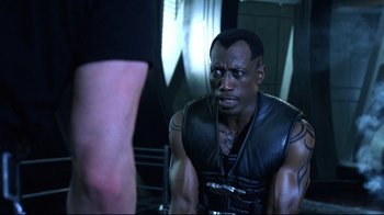 Movie still from “Blade II” (2002), directed by Guillermo del Toro – A man in a black leather vest looking at another man in a black leather vest; Close Up shot, Over the shoulder angle