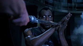 Movie still from “Blade II” (2002), directed by Guillermo del Toro – A man is holding a sword in his hands; Close Up shot, Over the shoulder angle