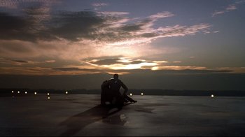 Movie still from “Blade II” (2002), directed by Guillermo del Toro – A man sitting on top of a skateboard on top of an ice rink; Extreme Wide shot, Low angle