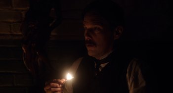 Movie still from “Tesla” (2020), directed by Michael Almereyda – A man holding a candle in a dimly - lit room; Close Up shot, Low angle