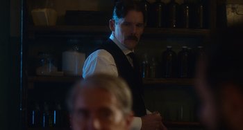 Movie still from “Tesla” (2020), directed by Michael Almereyda – A man standing in front of another man in a room; Close Up shot, Over the shoulder angle