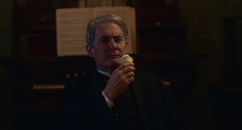 Movie still from “Tesla” (2020), directed by Michael Almereyda – An older man holding an apple in his hand; Close Up shot, Low angle