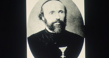 Movie still from “Tesla” (2020), directed by Michael Almereyda – An old black and white photo of a man with a medal; Close Up shot, Low angle