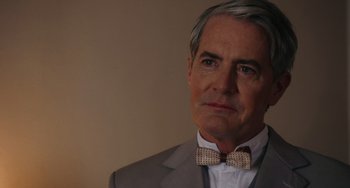 Movie still from “Tesla” (2020), directed by Michael Almereyda – A person wearing a suit and a bow tie; Close Up shot, Over the shoulder angle