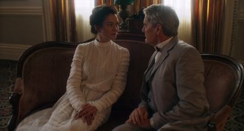 Movie still from “Tesla” (2020), directed by Michael Almereyda – A man and a woman sitting on a couch talking to each other; Medium shot, Over the shoulder angle