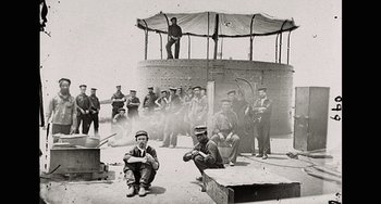 Movie still from “Tesla” (2020), directed by Michael Almereyda – A group of men standing next to each other on top of a building; Wide shot, Low angle