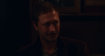 Movie still from “Tesla” (2020), directed by Michael Almereyda – A person wearing a suit and tie; Close Up shot, Over the shoulder angle