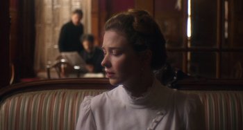 Movie still from “Tesla” (2020), directed by Michael Almereyda – A woman sitting in front of a laptop computer on a couch; Close Up shot, Over the shoulder angle