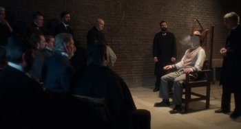 Movie still from “Tesla” (2020), directed by Michael Almereyda – A group of men standing in front of a brick wall; Wide shot, Over the shoulder angle
