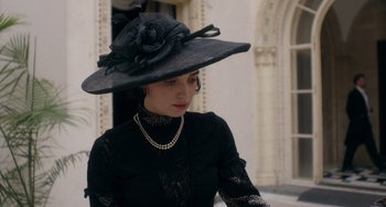Movie still from “Tesla” (2020), directed by Michael Almereyda – A woman wearing a black dress and a black hat; Medium shot, Low angle