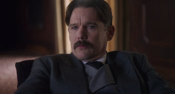 Movie still from “Tesla” (2020), directed by Michael Almereyda – A person wearing a suit and tie; Close Up shot, Low angle
