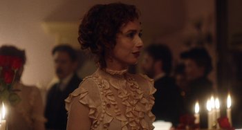 Movie still from “Tesla” (2020), directed by Michael Almereyda – A woman with curly hair wearing a white dress; Close Up shot, Over the shoulder angle
