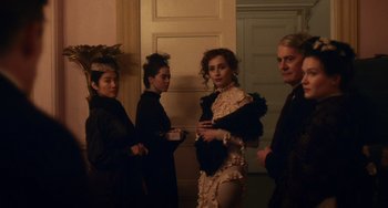 Movie still from “Tesla” (2020), directed by Michael Almereyda – A group of people standing next to each other in front of a door; Medium shot, Low angle