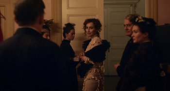 Movie still from “Tesla” (2020), directed by Michael Almereyda – A group of people standing in a room; Medium shot, Over the shoulder angle