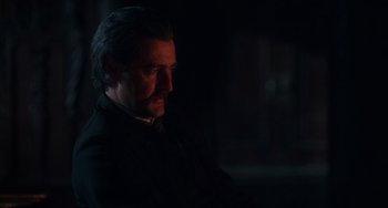 Movie still from “Tesla” (2020), directed by Michael Almereyda – A man in a dark room with a beard; Close Up shot, Over the shoulder angle
