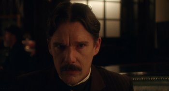 Movie still from “Tesla” (2020), directed by Michael Almereyda – A person wearing a suit and tie; Close Up shot, Low angle