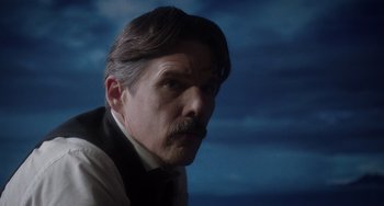 Movie still from “Tesla” (2020), directed by Michael Almereyda – A person wearing a suit and tie; Close Up shot, Low angle