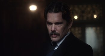 Movie still from “Tesla” (2020), directed by Michael Almereyda – A person wearing a suit and tie; Close Up shot, Over the shoulder angle
