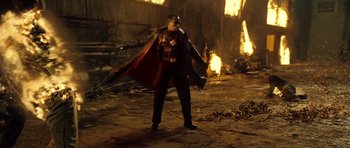 Movie still from “Blade: Trinity” (2004), directed by David S. Goyer – A man dressed as batman standing in front of a fire; Wide shot, Low angle