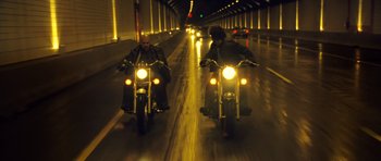 Movie still from “Blade: Trinity” (2004), directed by David S. Goyer – Two people riding motorcycles down a street at night; Wide shot, Low angle