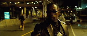 Movie still from “Blade: Trinity” (2004), directed by David S. Goyer – A man wearing sunglasses and a leather jacket in a parking lot; Close Up shot, Low angle