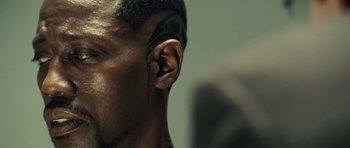 Movie still from “Blade: Trinity” (2004), directed by David S. Goyer – A man's ear with a tattoo on it; Close Up shot, Over the shoulder angle