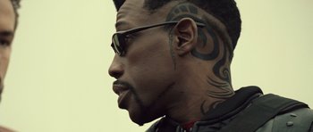 Movie still from “Blade: Trinity” (2004), directed by David S. Goyer – A person with tattoos on their face; Close Up shot, Over the shoulder angle