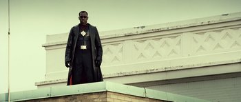 Movie still from “Blade: Trinity” (2004), directed by David S. Goyer – A man in a black leather jacket standing on top of a building; Medium shot, Low angle