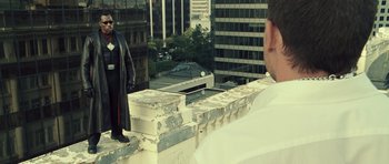 Movie still from “Blade: Trinity” (2004), directed by David S. Goyer – A man standing on top of a building looking out at the city; Wide shot, Over the shoulder angle