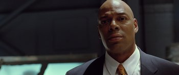 Movie still from “Blade: Trinity” (2004), directed by David S. Goyer – A man in a suit and tie looking at the camera; Close Up shot, Low angle